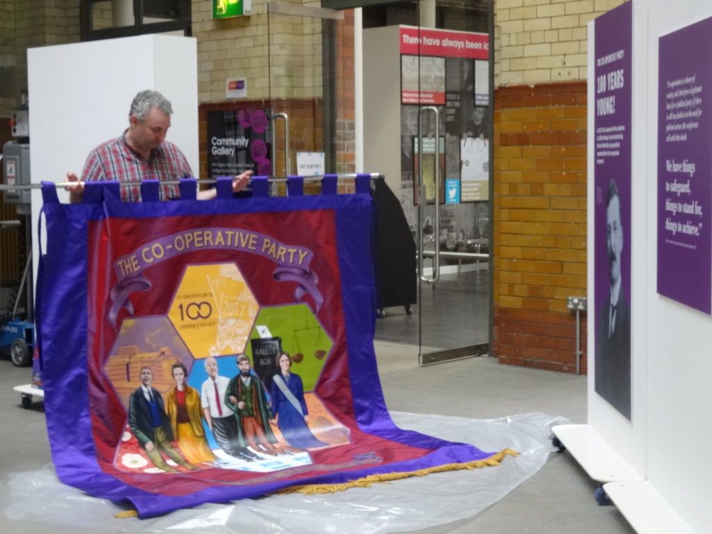 The PHM team prepare to hang the centenary banner