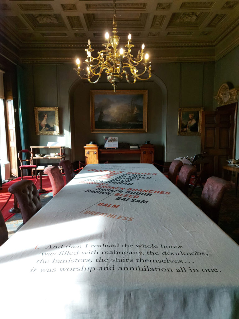 The angled text is designed to be read from the end, or form the long edge of the table, as visitors move around it